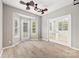 Open living room with wood flooring, lots of natural light, and a unique ceiling fan fixture at 10933 Sedgemoor E Ln, Charlotte, NC 28277