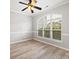 Bright living room featuring hardwood floors, a ceiling fan, and a large window offering ample natural light at 10933 Sedgemoor E Ln, Charlotte, NC 28277