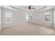 Spacious main bedroom with neutral carpet, tray ceiling, and a ceiling fan at 10933 Sedgemoor E Ln, Charlotte, NC 28277