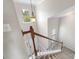 Carpeted staircase with wood railing and bright lighting at 10933 Sedgemoor E Ln, Charlotte, NC 28277