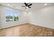 Bedroom featuring hardwood floors, a ceiling fan, and a large window overlooking the neighborhood at 1210 Skyview Rd, Charlotte, NC 28208