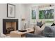 Cozy living room featuring a brick fireplace and sun-filled windows overlooking the backyard at 1210 Skyview Rd, Charlotte, NC 28208