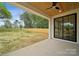 Covered patio overlooking a spacious backyard, featuring a ceiling fan and sliding glass door at 1210 Skyview Rd, Charlotte, NC 28208