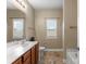 A bathroom featuring a sink, toilet and window with natural light at 134 Falling Leaf Ln, Statesville, NC 28677