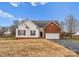Charming home features vinyl siding, brick accents, attached garage, and well-maintained lawn at 134 Falling Leaf Ln, Statesville, NC 28677
