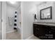 Well-lit bathroom features a dark vanity, a tub with a shower, and nautical-themed decor at 13925 Helen Benson Blvd, Davidson, NC 28036