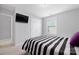 Comfortable bedroom with neutral walls, a wall-mounted TV, and a cozy striped bed at 13925 Helen Benson Blvd, Davidson, NC 28036