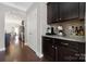 Butler's pantry showcasing granite countertops, dark cabinetry, and convenient access to the dining area at 13925 Helen Benson Blvd, Davidson, NC 28036