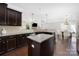 Open-concept kitchen featuring granite countertops, dark cabinetry, and stainless steel appliances at 13925 Helen Benson Blvd, Davidson, NC 28036