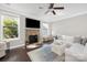 Bright living room features a stone fireplace, hardwood floors, and white sofa at 13925 Helen Benson Blvd, Davidson, NC 28036
