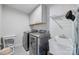 Well-lit laundry room featuring gray front load washer and dryer, utility sink and upper cabinets for storage at 14130 Sunnyhill Grove Rd, Davidson, NC 28036