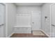 Functional mudroom with storage hooks, bench, and adjacent doors at 14130 Sunnyhill Grove Rd, Davidson, NC 28036