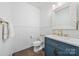 Stylish powder room with a blue vanity, marble countertop, and modern fixtures at 14130 Sunnyhill Grove Rd, Davidson, NC 28036