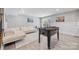 Bright recreation room with white sofa, area rug, game table, and sliding glass doors to outside at 14130 Sunnyhill Grove Rd, Davidson, NC 28036