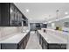 Stylish wet bar with black cabinets, stone countertops, a sink, wine racks, and beverage fridge at 14130 Sunnyhill Grove Rd, Davidson, NC 28036
