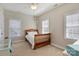 Bright bedroom with two windows, neutral colors, desk and chair, ceiling fan, and a classic wood bed frame at 142 Mills Ln, Fort Mill, SC 29708
