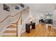 Hallway view with stairs, wooden floors, and glimpses of the living room with a fireplace at 142 Mills Ln, Fort Mill, SC 29708