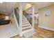 Finished basement stairs with wood treads and railing lead to an open living space and kitchen at 1426 Merrimont Ave, Kings Mountain, NC 28086