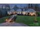 Exterior view of a luxury home with stunning landscape lighting at dusk with stone accents at 1426 Merrimont Ave, Kings Mountain, NC 28086