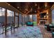 Cozy screened porch features a stone fireplace, ceiling fans, and string lights, perfect for outdoor living and entertaining at 1426 Merrimont Ave, Kings Mountain, NC 28086