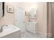 Bright bathroom with a white vanity, framed mirror, and hexagon tile flooring at 1513 Fletcher Broome Rd, Monroe, NC 28112