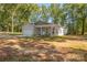 A charming single-story house featuring a covered front porch and attached garage, nestled among mature trees at 1513 Fletcher Broome Rd, Monroe, NC 28112