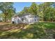 Back of home featuring light vinyl siding, small windows, and a concrete patio surrounded by a grassy yard at 1513 Fletcher Broome Rd, Monroe, NC 28112