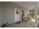 Close-up of a cozy covered front porch with chairs, a 'welcome' mat, and a wreath on the front door at 1513 Fletcher Broome Rd, Monroe, NC 28112