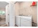 Bright laundry room features white washer and dryer, storage, and a nearby closet at 1513 Fletcher Broome Rd, Monroe, NC 28112