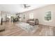 Open-concept living room and kitchen features hardwood floors, multiple windows, and modern furnishings at 1513 Fletcher Broome Rd, Monroe, NC 28112
