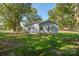 The back of the home features several windows and a back entrance; lush lawn surrounded by trees at 1513 Fletcher Broome Rd, Monroe, NC 28112