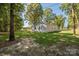 A view of the side of the house, surrounded by mature trees and a lush green lawn at 1513 Fletcher Broome Rd, Monroe, NC 28112