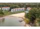 Aerial view of lakefront condos with a beach, boat slips, and a community pool at 17811 Half Moon Ln # C, Cornelius, NC 28031