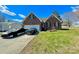 Charming brick home with a manicured lawn and driveway featuring two cars at 1896 Independence Sq, Kannapolis, NC 28081