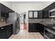 Bright kitchen with black cabinets, stainless steel refrigerator, and stylish backsplash at 196 Gabriel Dr, Mooresville, NC 28115