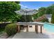 Inviting pool area featuring a striped umbrella, patio seating, and lush landscaping at 196 Gabriel Dr, Mooresville, NC 28115