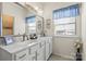 Bright bathroom featuring a glass-enclosed shower, double sinks, and a window with natural light at 2147 Stevens Mill Rd, Matthews, NC 28104