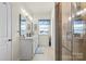 Bright bathroom featuring a glass-enclosed shower, double sinks, and a window with natural light at 2147 Stevens Mill Rd, Matthews, NC 28104