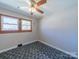 Bedroom featuring a ceiling fan, two windows and patterned carpeting at 2310 Clay St, Kannapolis, NC 28083