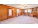 Cozy living room featuring wood paneling, natural light, and vintage ceiling fan at 2310 Clay St, Kannapolis, NC 28083