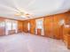 Spacious living room with wood paneling, vintage ceiling fan and large windows at 2310 Clay St, Kannapolis, NC 28083