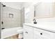 Bright bathroom showcasing a tub with shower head, white vanity, and white tiling at 2702 Robyns Glen Dr, Charlotte, NC 28269