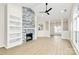 Bright, open-concept living room with modern light-toned floors, a stone fireplace, built-in shelves, and neutral walls at 2702 Robyns Glen Dr, Charlotte, NC 28269