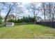 Large backyard with a privacy fence, shed, and mature trees offering a serene outdoor retreat at 312 Flint St, Charlotte, NC 28216