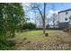 Backyard featuring mature trees, partial fencing, and rear building access at 314 Flint St, Charlotte, NC 28216
