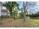 An open backyard with mature trees, a storage shed, and partial fencing at 314 Flint St, Charlotte, NC 28216