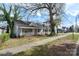 A cute one-story home with a welcoming front porch and light blue exterior, surrounded by trees at 314 Flint St, Charlotte, NC 28216