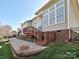 A large backyard with brick patio, fire pit, and steps to a wooden deck at 315 Drake Park Ave, Fort Mill, SC 29708