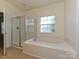 Bathroom with tiled shower, tub and window that provides natural light at 315 Drake Park Ave, Fort Mill, SC 29708