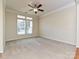 Spacious bedroom with neutral carpeting, a ceiling fan, and a large window offering ample natural light at 315 Drake Park Ave, Fort Mill, SC 29708